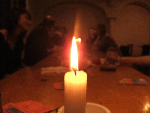 Eine brennende Kerze, dahinter Teilnehmer der Studienfahrt